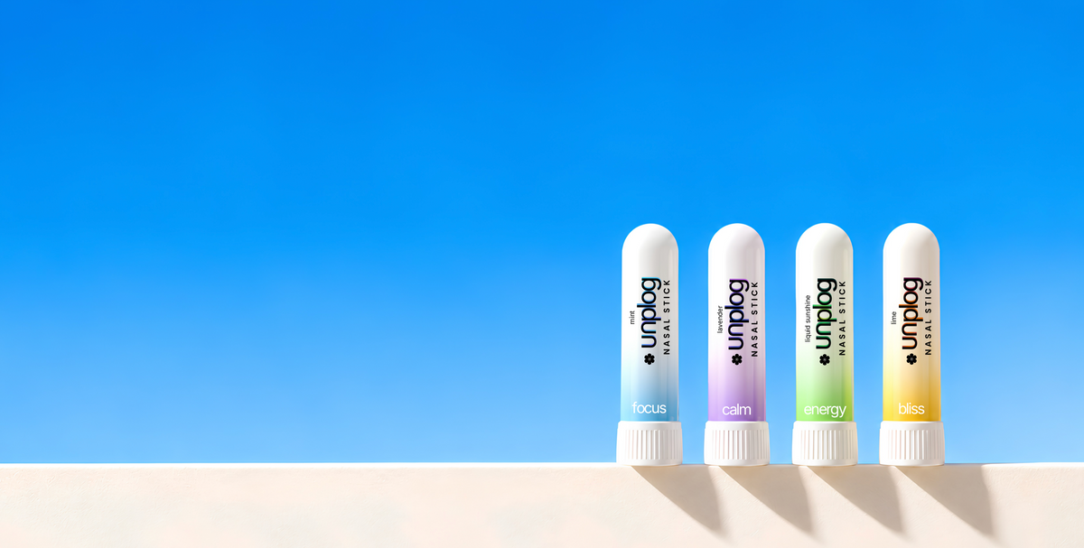 Unplog Focus, Calm, Energy and Bliss aromatherapy nasal sticks lined up on a sunny ledge against a blue sky